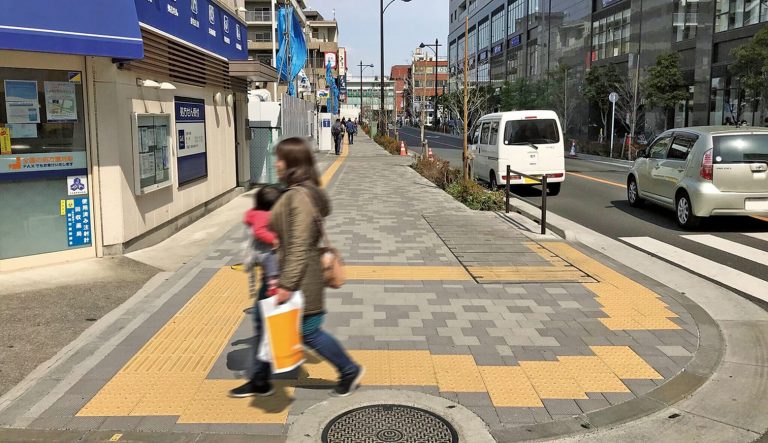 暗い印象の歩道をインターで明るい街並みに
