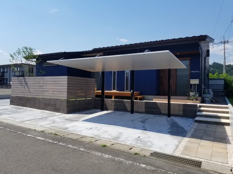 青色のモダン住宅を引き立てる茶系ブロックの外周