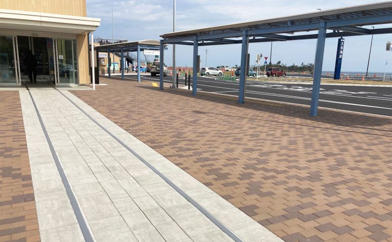 線路のレールが建物に導く遊び心のある駅前広場