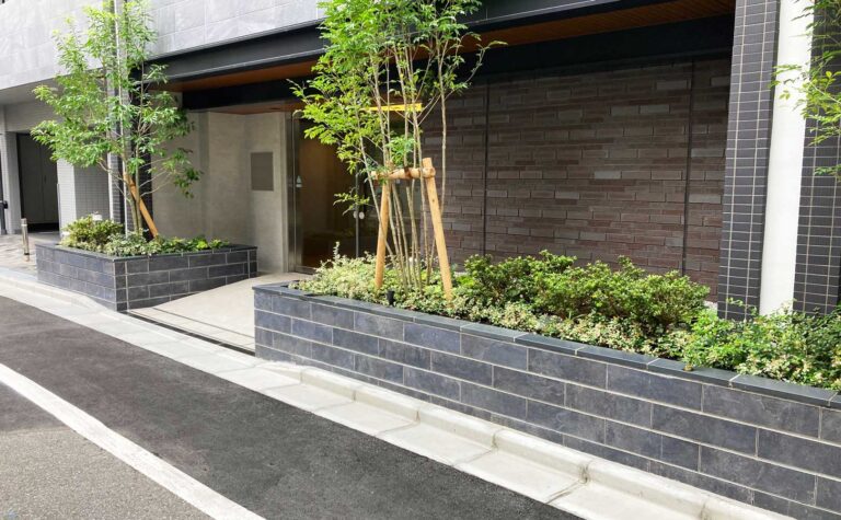 シックな黒色が高級感を演出するエントランス横の花壇