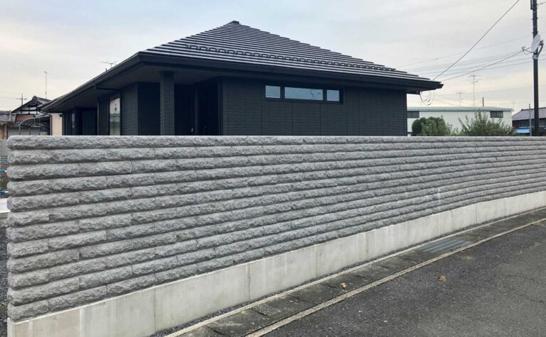 住宅とのコントラストが効いた割肌ブロックの塀