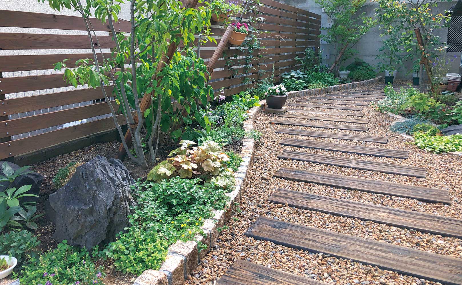 天然木のステップ（シダースリーパー）の園路にピンコロの花壇を合わせたナチュラルなお庭