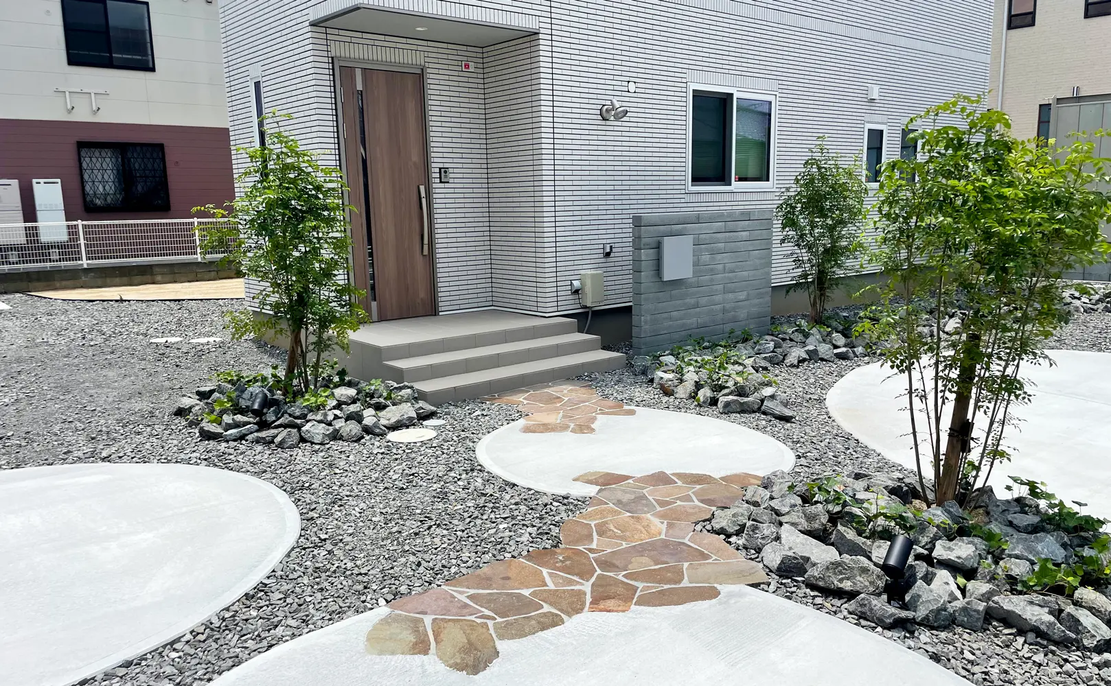 円形の土間と土間をジャワ鉄平で繋いだ遊び心のあるアプローチ
