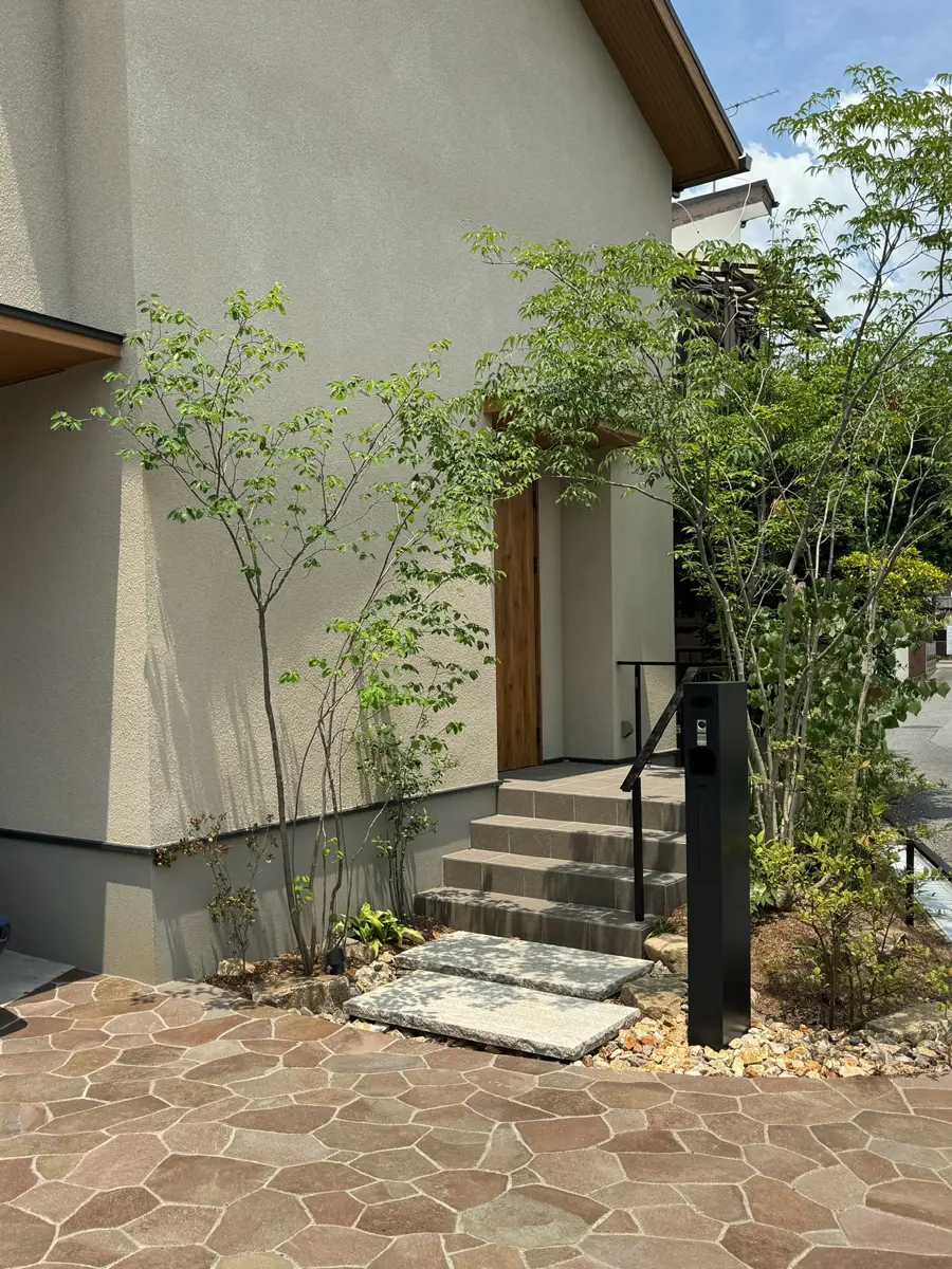 雑木のアーチをくぐる玄関アプローチ