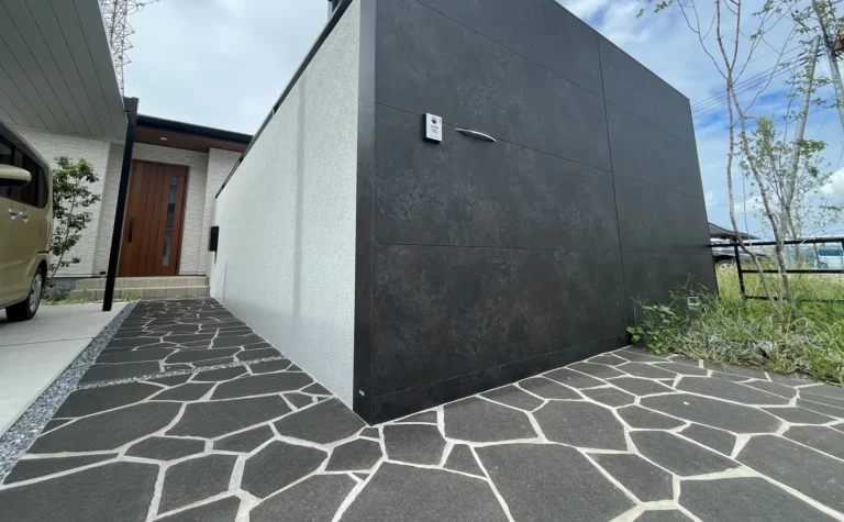 シャープな建築に合わせた黒色天然石のアプローチ